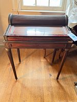 Front view of closed tambour desk on stand