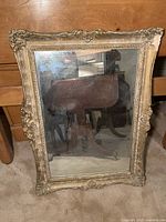 Full view of rectangular antique style mirror with ornate decorated frame, showing overall condition and reflective glass.