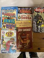 A collection of comic books featuring Marvel and DC titles such as Doc Savage, Batman Year 3, The Amazing Spider-Man, and Doctor Strange, showing the front covers and title details.
