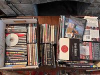 Two boxes of DVDs arranged in stacks on a table, titles include The Tudors, Pulp Fiction, Easy Rider, among others.