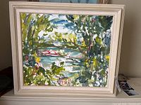 Front view of framed oil painting showing impressionistic landscape scene with foliage and water