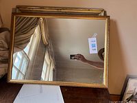 Full view of rectangular mirror with gold frame showing size and mounting location.