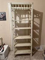 Front view of the tall, solid wood bookshelf painted in a light color showing the full height and shelving units.