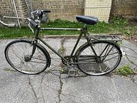 Full side view of vintage Raleigh 3-speed bike showing frame, tires, saddle, and handlebars in outdoor setting.