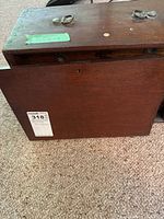 Front view of wooden tool cabinet showing overall size and structure with metal handles on top.