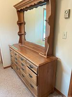 Full view of solid wood dresser with 7 drawers and attached mirror with decorative trim