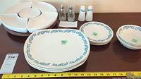 Five large plates, four side plates, four bowls, two glass salt and pepper shakers with EP silver tops, two crystal salt and pepper shakers, white segmented Lazy Susan serving tray, measuring ruler.