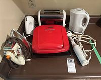 Photo showing all items including George Foreman grill, hand mixer, iron, kettle, toaster and handheld blender.