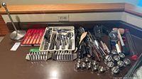 Overview of all kitchen utensils including knives, cooking tools, and holders arranged on countertop.