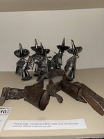 Antique European goat bells with leather straps and metal and wooden bells, showing wear and heavy use.