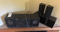 Sony portable stereo AM/FM radio cassette recorder with two external Polk RM7 speakers placed on table.