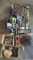 Overview of the lot showing multiple hand tools including crowbars, spirit levels, axes, sledgehammer, door handles, hot glue gun, C-clamps, metal brushes, and assorted small hardware in boxes and bags.