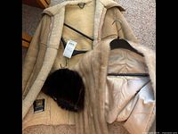 Sheepskin jacket with interior visible showing wool lining, along with mink stole and fur hat present