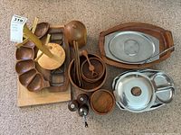 Wide view of all items arranged showing various wooden and metal serveware pieces including trays, bowl, and shakers.