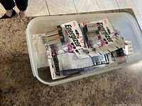 Photo of a plastic bin containing multiple new Energizer 9V alkaline batteries in sealed packaging.