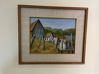 Full view of the framed print showing the rustic barn, houses, and milk cans with wooden frame and beige mat.