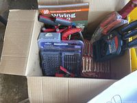 Photo of open box with assorted hand tools including red handled screwdrivers, wrenches, and Mastercraft drill and driver bit sets in plastic cases.