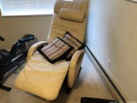 Full front-quarter view of beige leather massage chair in semi-reclined position