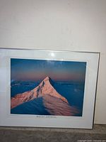 Photo of framed Mount Aspiring mountain photograph, showing snow-covered peak with lighting from sunset or sunrise.