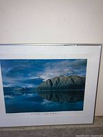 Photo of framed mountain landscape photo titled 'Autumn Lake Hawea' with reflection in lake, blue sky, and clouds.