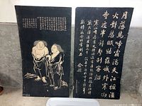 Two black hardboard-mounted Chinese tomb rubbings, one with two figures and the other with calligraphy