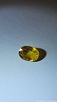 Photo showing the oval cut canary yellow sapphire with vibrant color and clarity.