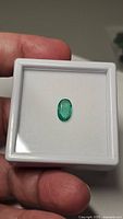 Overall view of oval emerald in white display box