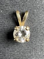 Front view of pendant showing round diamond set in 4 prongs with bail