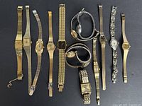 Group photo showing 10 vintage women's watches in mostly gold-tone metal bands and various face shapes and sizes, laid out on black background.