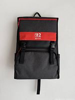 Front view of the black rectangular backpack with red accent and Nintendo Switch 2 logo on front flap.
