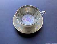 Top-down view showing center floral design and gold trim on cup and saucer