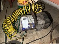 Full view of rusted Campbell Hausfeld small air compressor with yellow coil hose attached, power cord visible