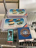 Photo of two Classic Trucks die cast toy boxes, a biplane model box, and a teal pencil sharpener on a metal rack.