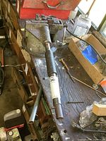 Overall front view of the metal bender on workbench showing lever handle, clamp assembly, and base.