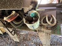Overview of roof holding horseshoes and bucket with electrical insulators showing wear and rust