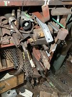 Metal fabrication parts including the large solid steel auger and various other metal pieces arranged on shelving.