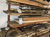 Overall view of metal bars and rods bundled and placed on shelves along with some lumber above.