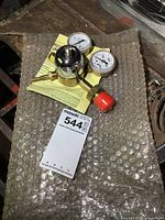 Photo of two new welding pressure gauges with instruction sheet on bubble wrap