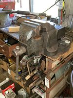 Side view showing vise mounted on workbench with visible muscle wear and usage marks.