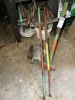 View of the sledge hammer, wrecking bars, bending tools, and tire wrenches grouped on floor by a workbench