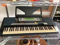 Full view of Yamaha PSR-540 electronic keyboard showing keys, speakers, and control panel on a shelf.