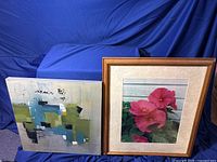 Two framed wall art pieces displayed together, one abstract painting and one photo of pink roses