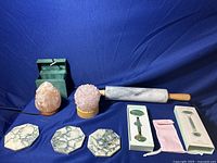 Full view of pink quartz lamp, salt lamp, marble dough roller, and jade facial roller sets displayed on a blue background