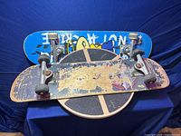 Two skateboards lying on top of the round balance twister board on a blue surface