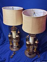 Pair of vintage lamps with yellow felt drum shades shown against a blue background.