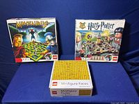 Three boxed LEGO items: Minotaursus board game, Harry Potter board game, and Minifigure Faces set.