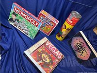 View of all five games including Monopoly, Kool-Aid Trivia, Vegas board game, 3D puzzle, and cylindrical building blocks game