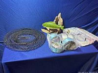 Overview of fishing gear including fishing nets, tackle box, fishing line rolls and fish figurine