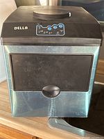 Front view of the Della mini ice maker showing control panel and closed ice storage door.