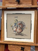 Close-up photo showing the detailed sand art painting with the Native American figure, signature, and textured background.